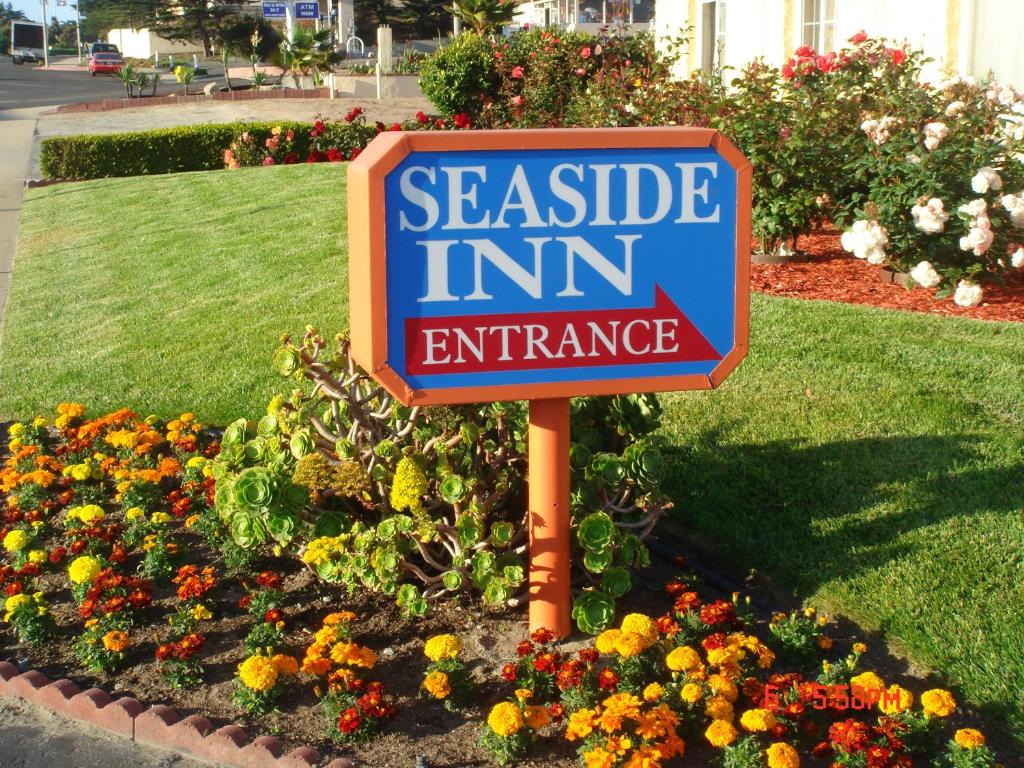 un panneau indiquant l'entrée de l'auberge sénate dans un jardin dans l'établissement Seaside Inn Monterey, à Seaside