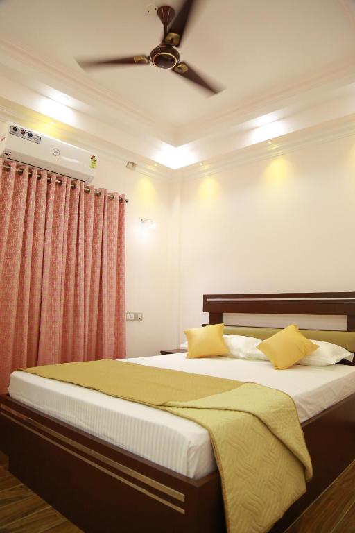 1 dormitorio con 1 cama y ventilador de techo en Villino Kalipparambil, en Ernakulam