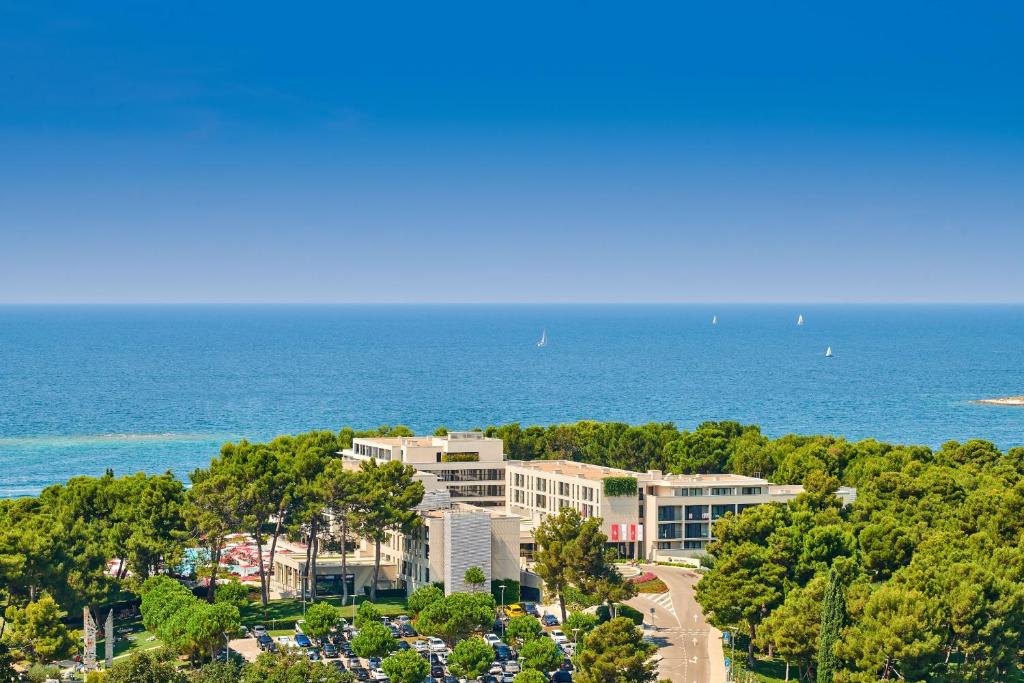 an aerial view of a building near the ocean at Hotel Parentium Plava Laguna in Poreč