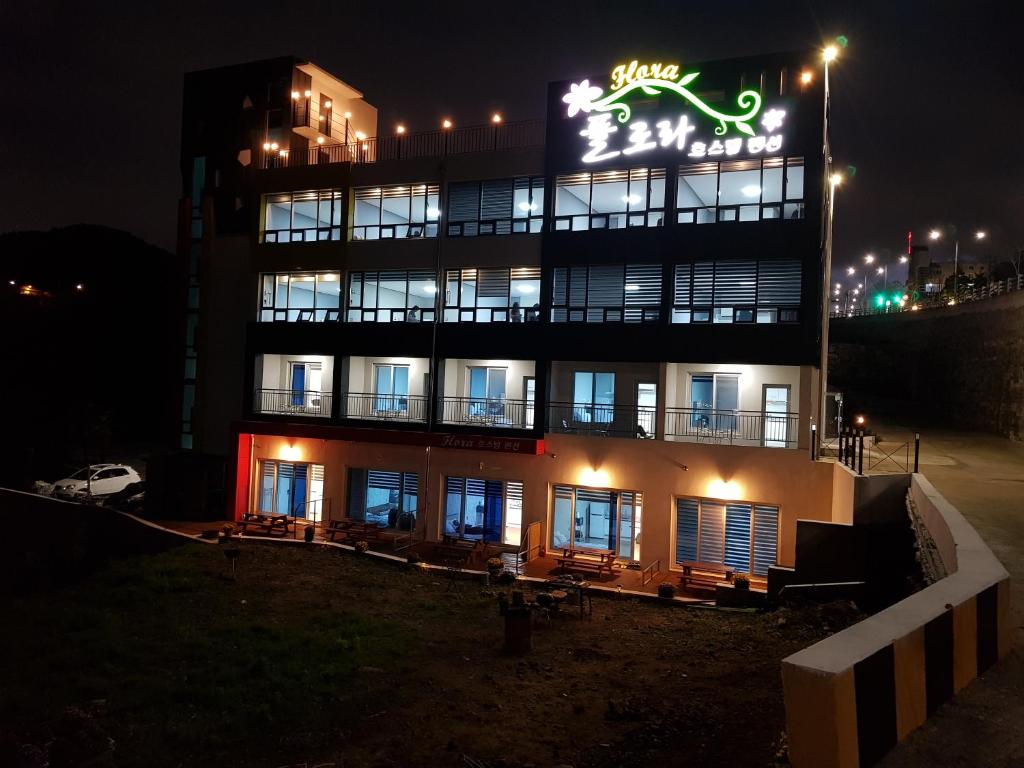 a building with a sign on it at night at Flora hostelpension in Yeosu