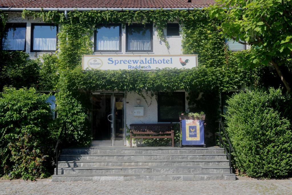 un bâtiment avec un banc devant lui dans l'établissement Spreewaldhotel Garni Raddusch, à Vetschau/Spreewald