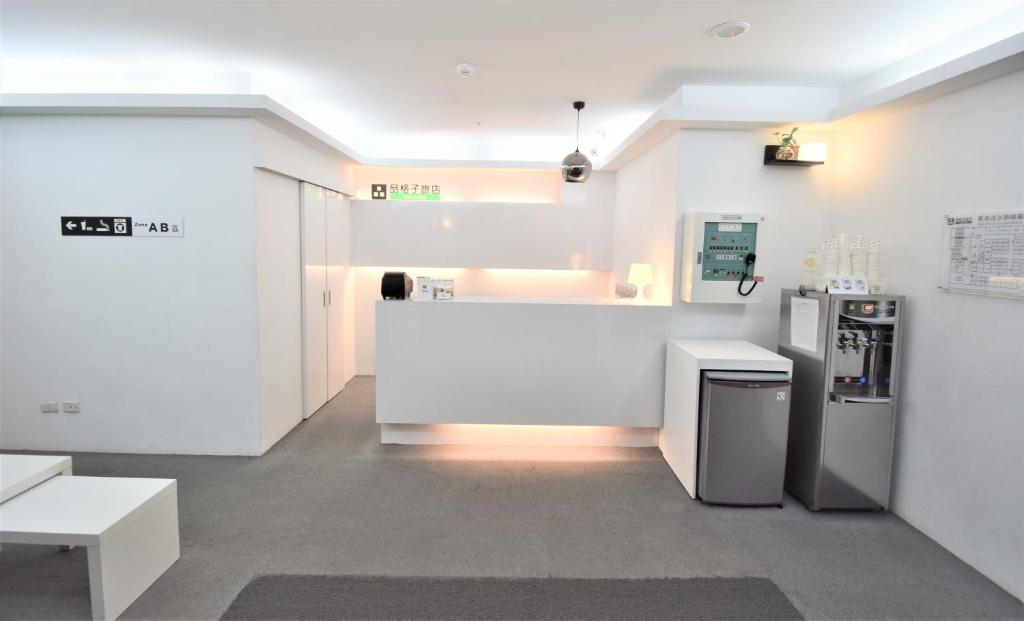 a white room with a counter and a refrigerator at Inn Cube - Ximen in Taipei