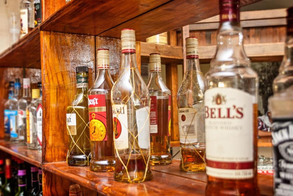 a bunch of bottles of alcohol on a shelf at Nolangeni Hotel in Kokstad