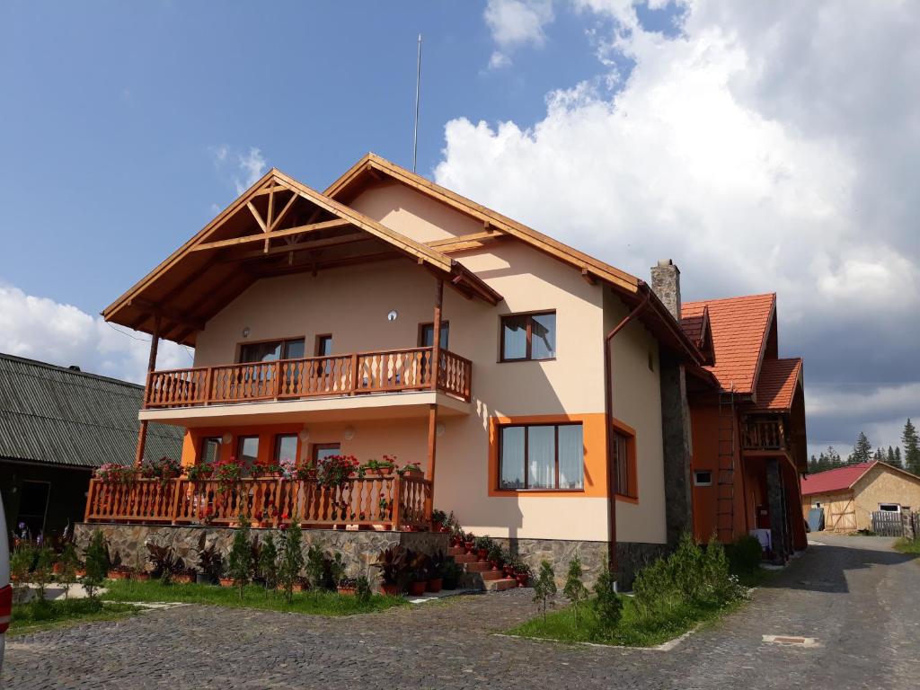 a house with a balcony on the side of it at Pensiunea Teo in Bilbor