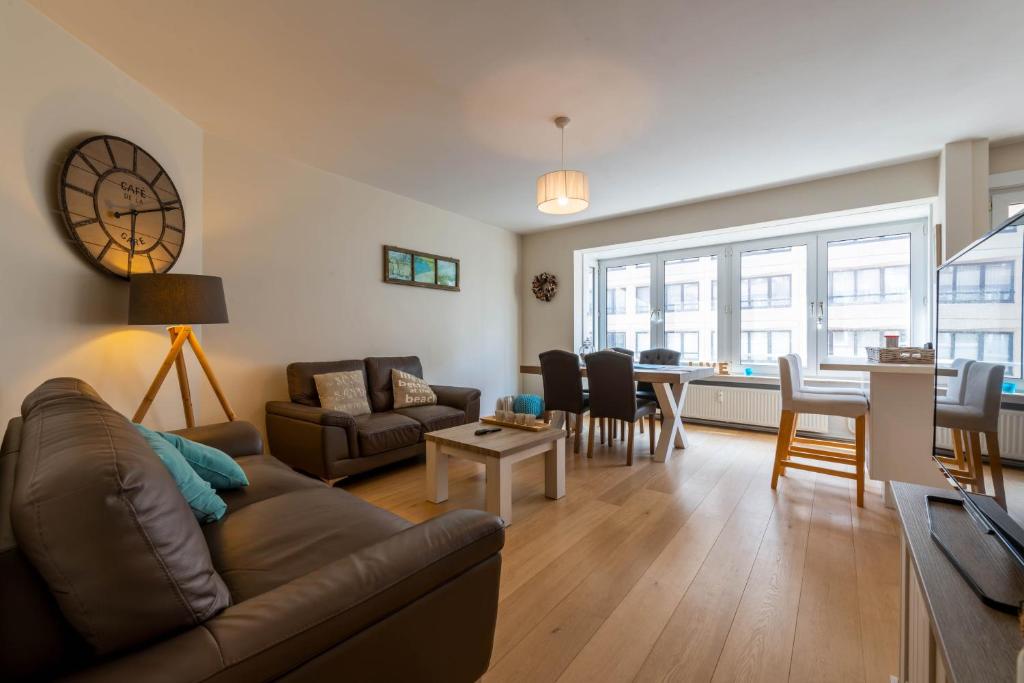 un soggiorno con divano e tavolo di Apartment Kursaal Ostend a Ostenda