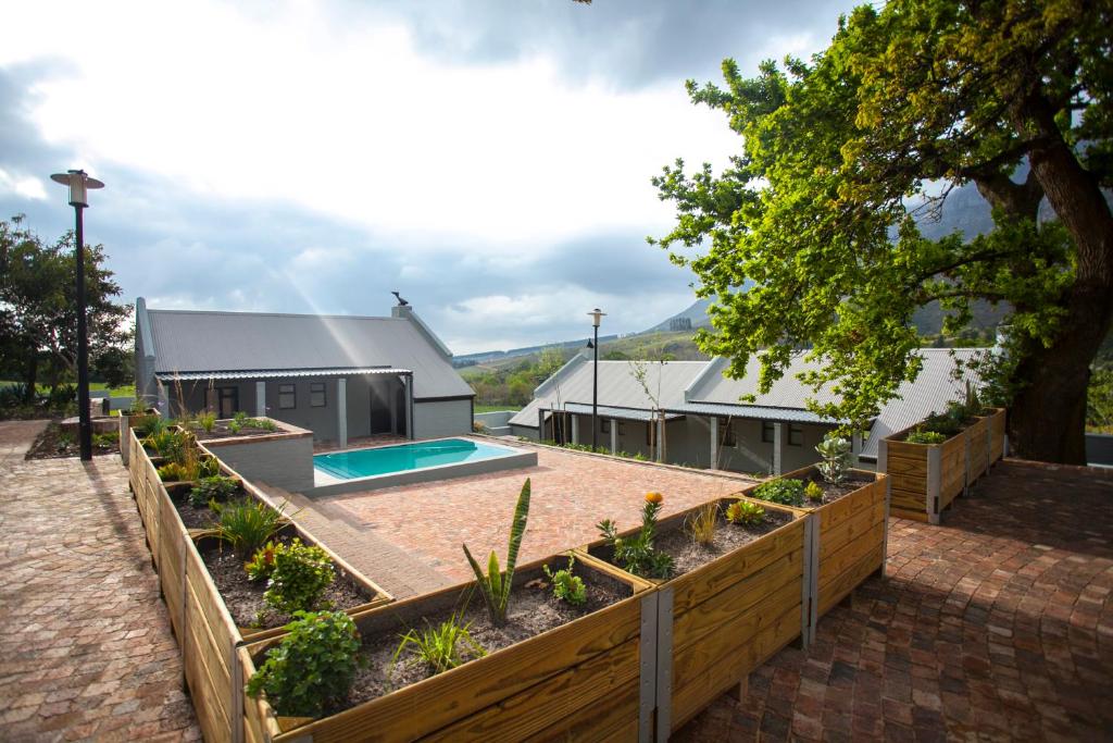 un jardín con piscina frente a una casa en Mont Angelis en Stellenbosch