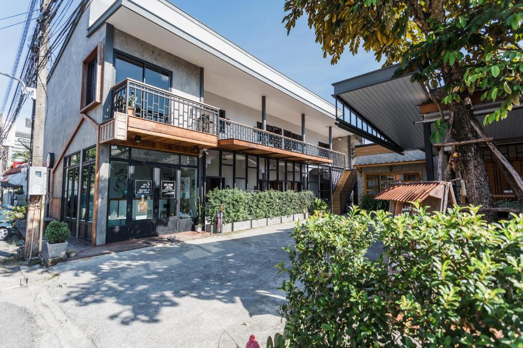 a building with a balcony on the side of it at Sleepy House Chiang Rai in Chiang Rai