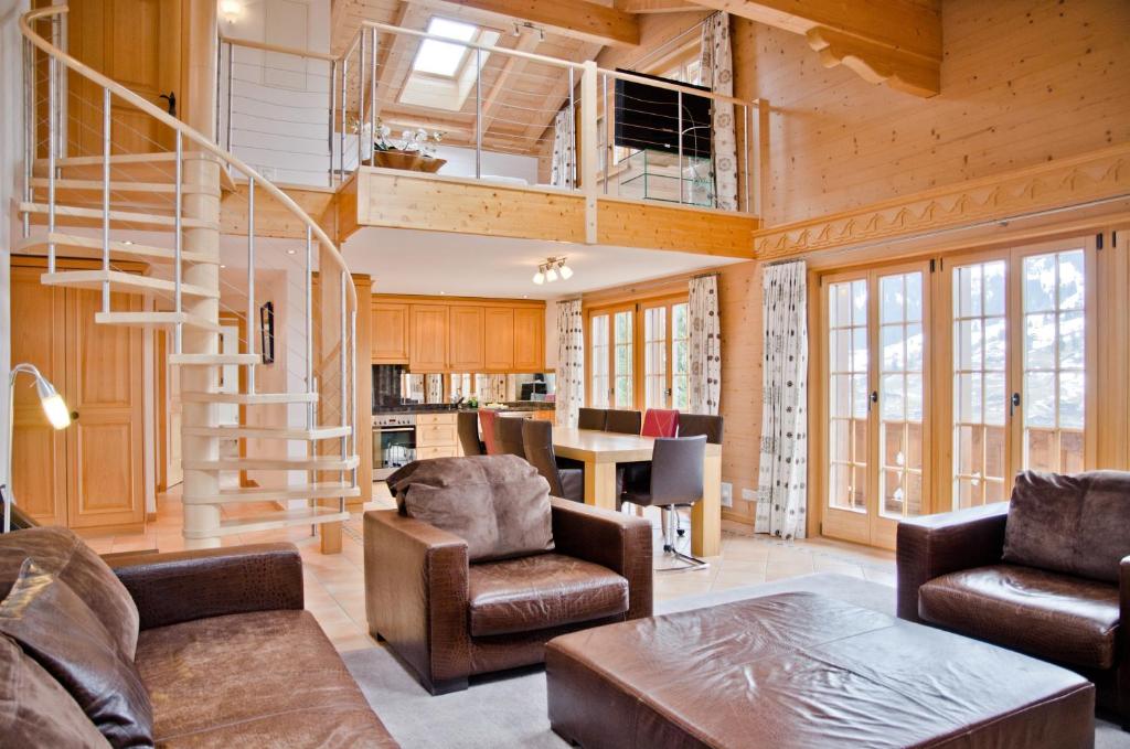 uma sala de estar com uma escada em espiral numa casa em Apartment Bärgrose - GRIWA RENT AG em Grindelwald