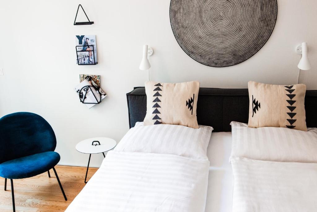 ウィーンにあるThe BL42 - Vienna Concept Apartmentsのベッドルーム1室(ベッド2台、青い椅子付)