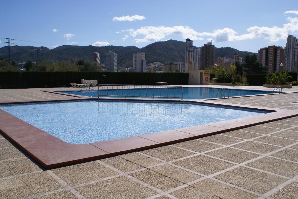 a swimming pool with a city in the background at Apartamentos Paraiso 10 in Benidorm