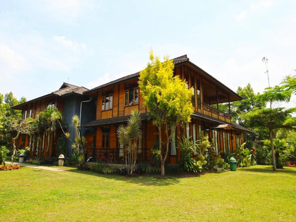 uma casa com um jardim verde em frente em Villa Gardenia Bandung em Lembang