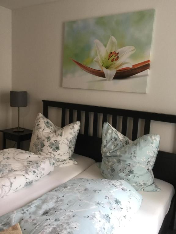 a bedroom with two beds with pillows and a painting at Zum Bürgerhof Petra in Saarlouis