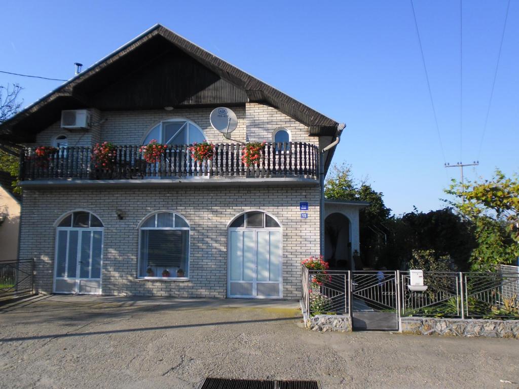 a brick house with a balcony with flowers on it at Rooms Mila in Rezovac