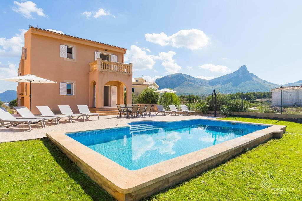 a villa with a swimming pool in front of a house at Dones Aigua in Colonia de Sant Pere