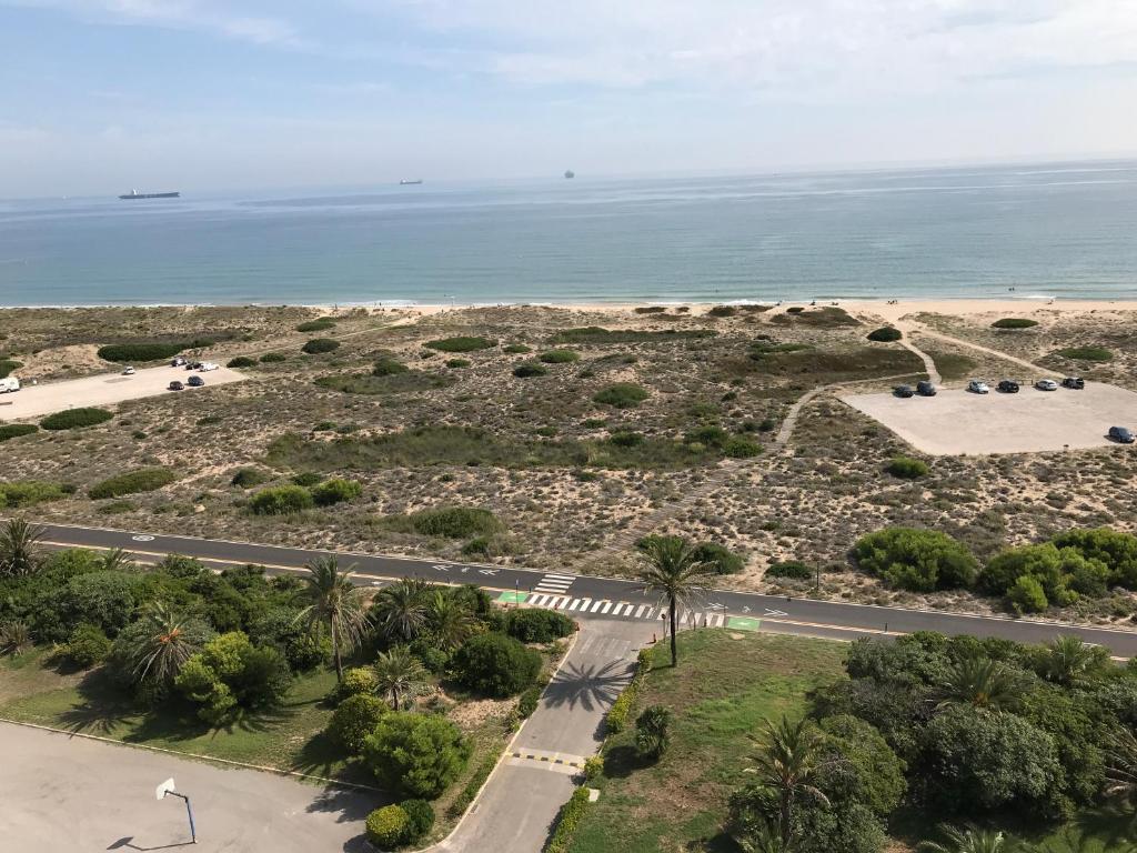 eine Luftansicht auf eine Straße und den Strand in der Unterkunft Gran Apartamento, un lujo en playa El Saler - Valencia in El Saler