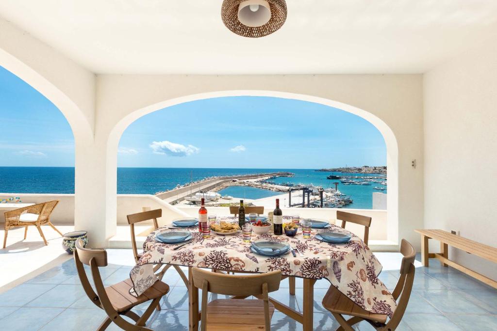 レウカにあるAttico del Blu by BarbarHouseのダイニングルーム(テーブル付)が備わり、海の景色を望めます。