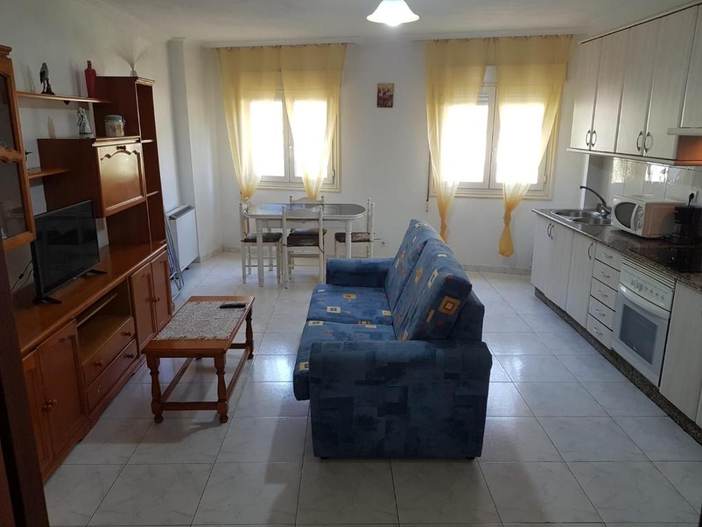 ビラガルシーア・デ・アロウサにあるPiso en Villagarcia de Arosaのリビングルーム(青いソファ、テーブル付)