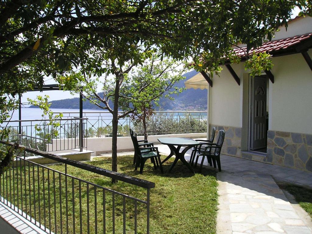 una mesa y sillas en un patio con vistas al agua en Villa Pegasos, en Chrysi Ammoudia