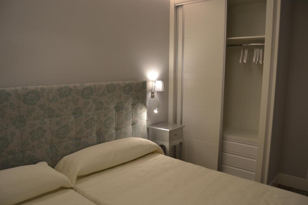 een slaapkamer met een bed met een hoofdeinde en een lamp bij Hotel Español in La Pueblanueva