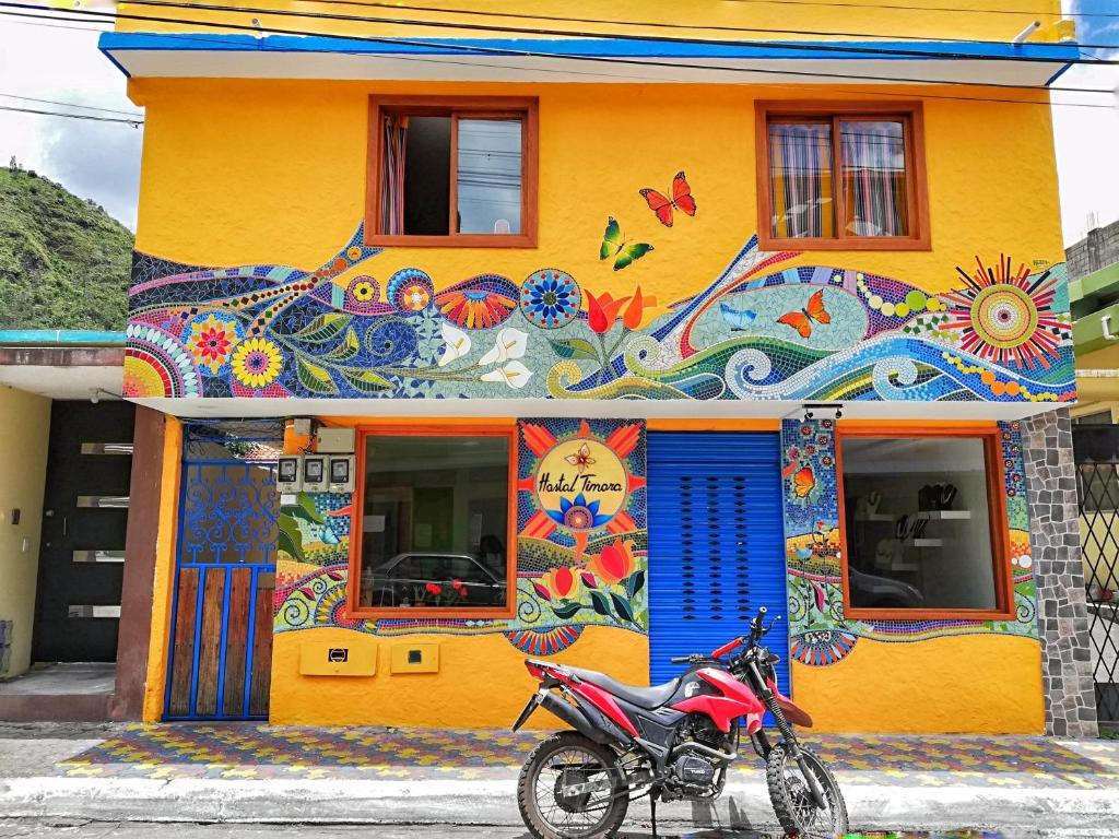 a motorcycle parked in front of a colorful building at Hostal Timara in Baños