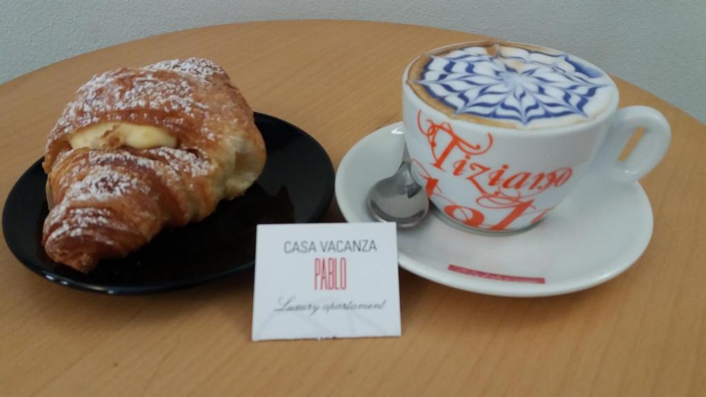 a pastry on a plate next to a cup of coffee at Casa Vacanza Pablo Castello in Cagliari