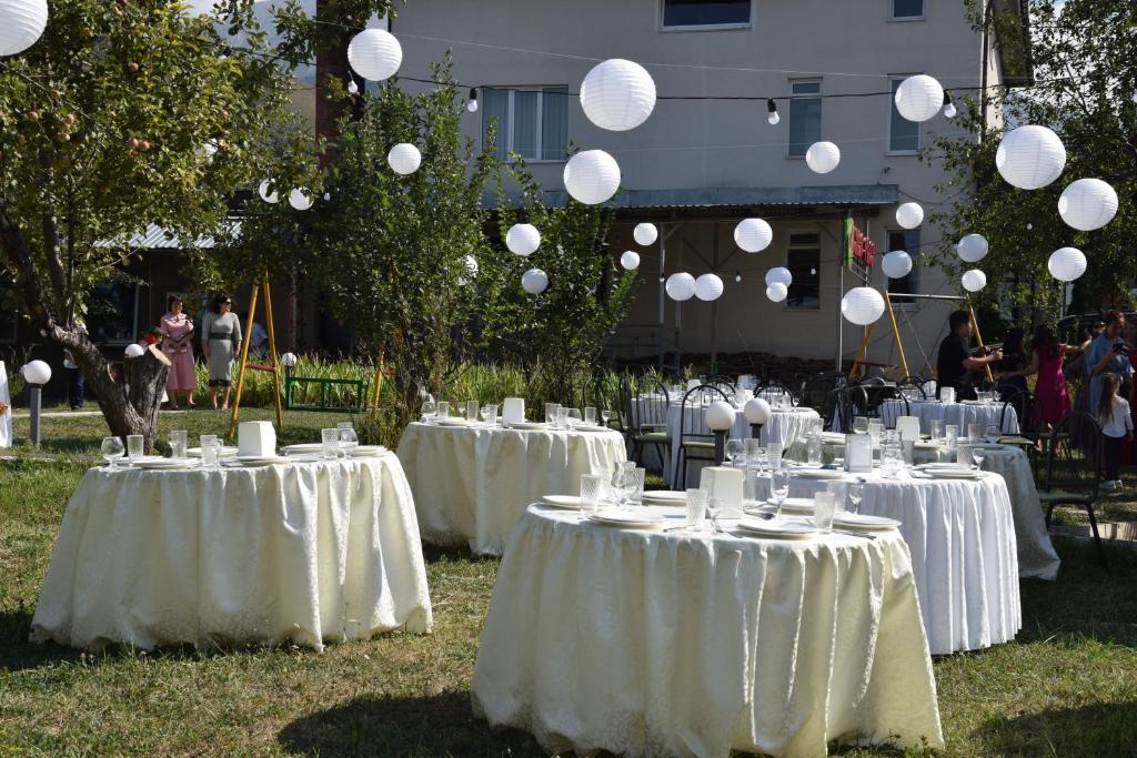 a group of tables with white table linens and balloons at AlmaPort in Talghar