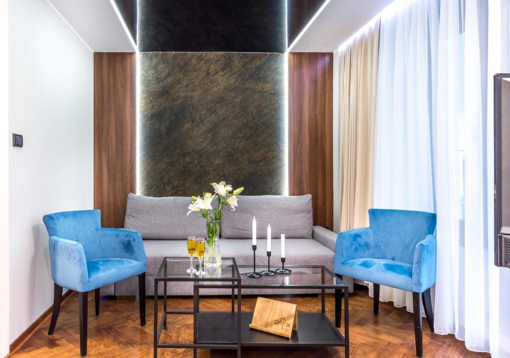 a living room with a couch and blue chairs at Onyx luxury apartments in Belgrade
