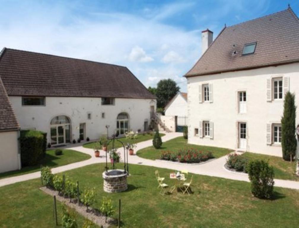 une grande maison blanche avec un jardin en face de celle-ci dans l'établissement Hotel l'Orée Des Vignes, à Gilly-lès-Cîteaux