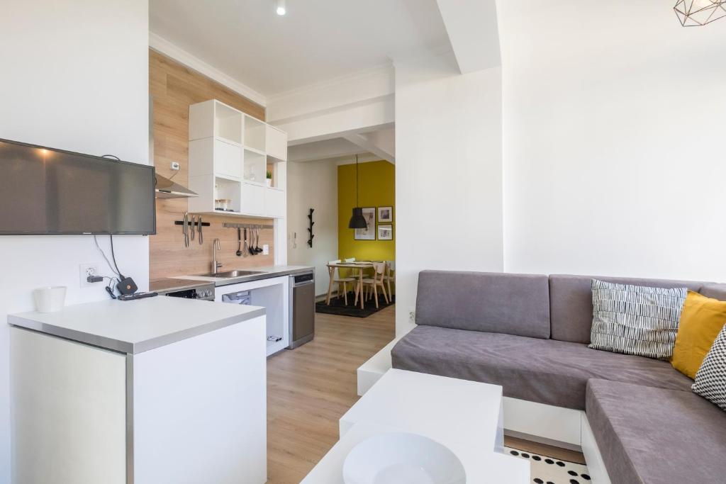 a living room and kitchen with a couch and a table at blueWaveplace - Contemporary Home in Center of Sofia in Sofia