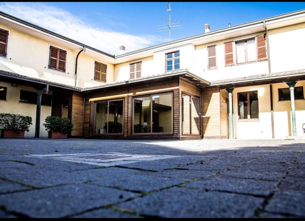 un grande edificio bianco con finestre in vetro su una strada di Manfredi ristorante con alloggio a Romentino