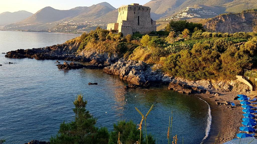a castle on a hill next to a body of water at Villa Crawford in San Nicola Arcella