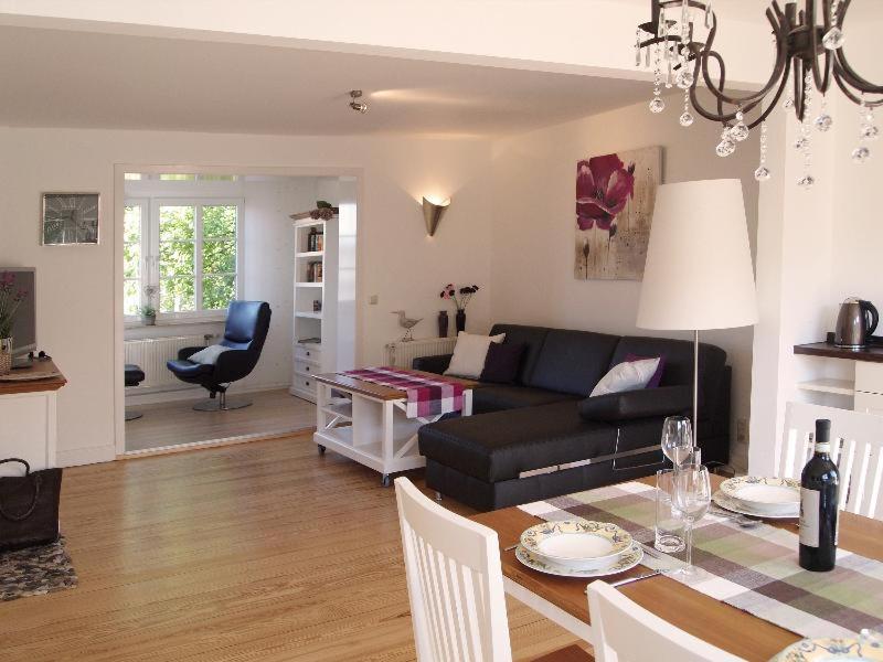 a living room with a black couch and a table at Ferienwohnung Alte Liebe 2 in Travemünde