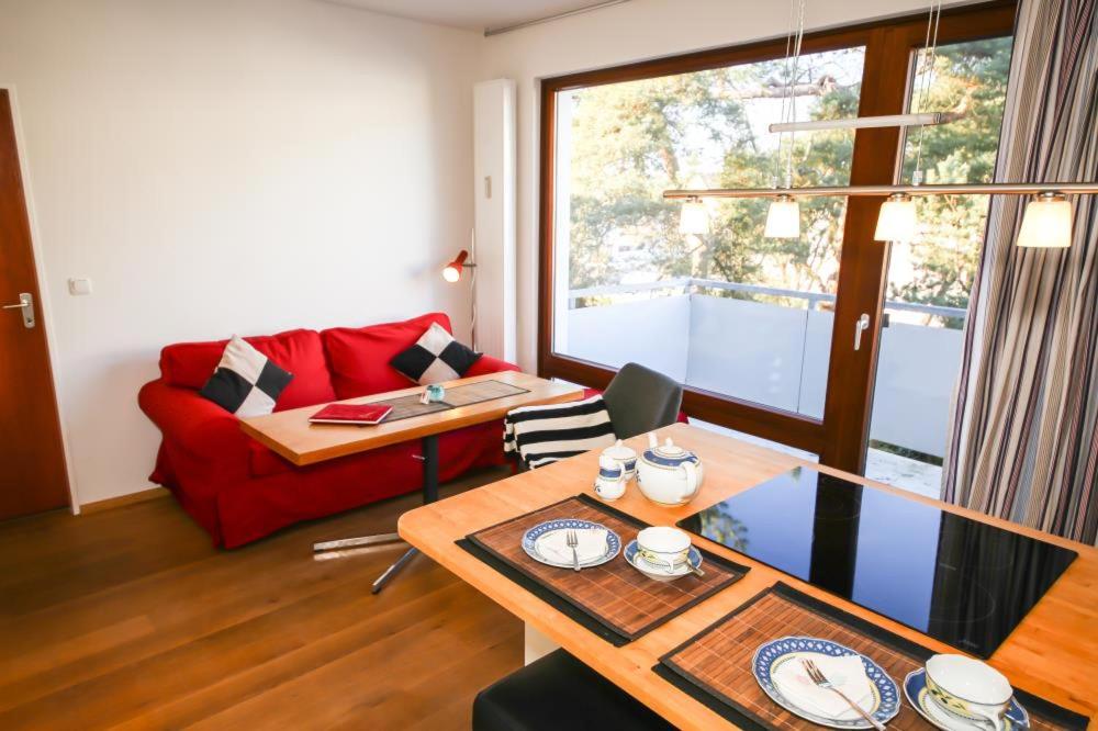 a living room with a red couch and a table at Ferienwohnung Hamm in Timmendorfer Strand