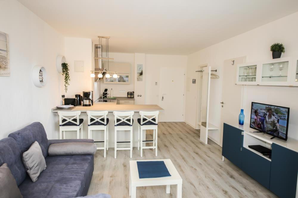 een woonkamer met een bank en een keuken bij Ferienwohnung Ostseeperle in Scharbeutz