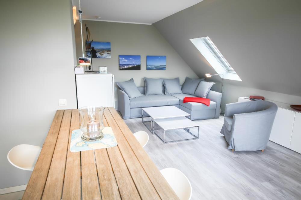 ein Wohnzimmer mit einem Sofa und einem Tisch in der Unterkunft Ferienwohnung Hideaway in Scharbeutz