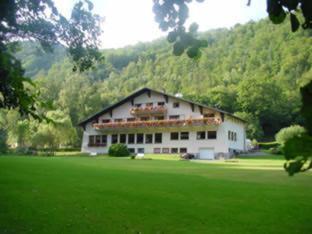 een groot wit gebouw in een veld van groen gras bij La Fischhutte, The Originals Relais (Relais du Silence) in Mollkirch