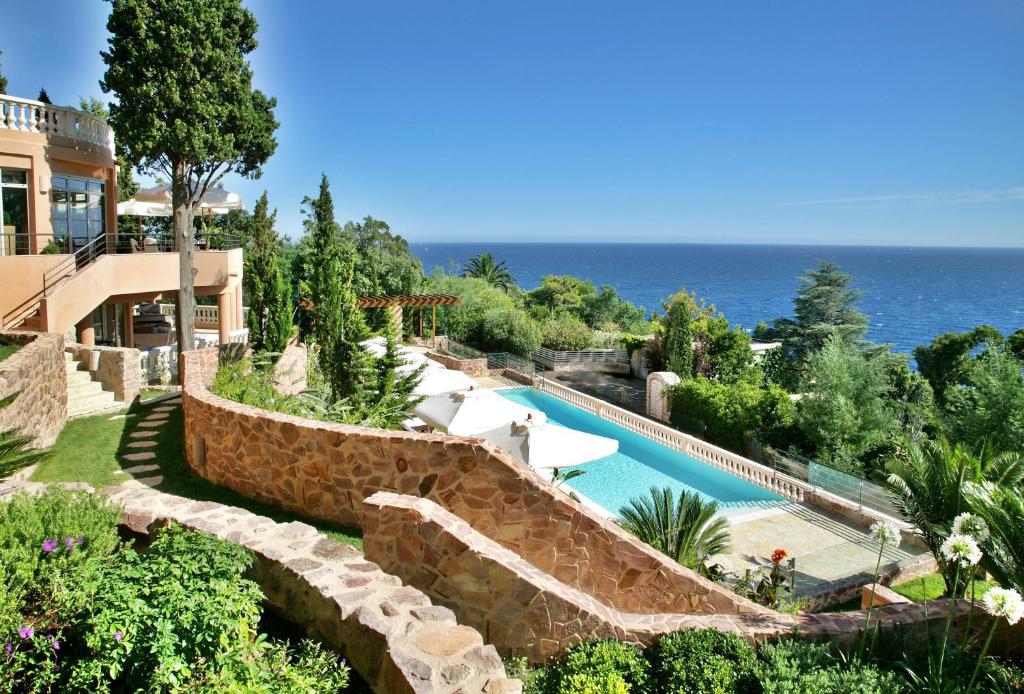 a house with a swimming pool next to the ocean at Tiara Yaktsa Côte d’Azur in Théoule-sur-Mer