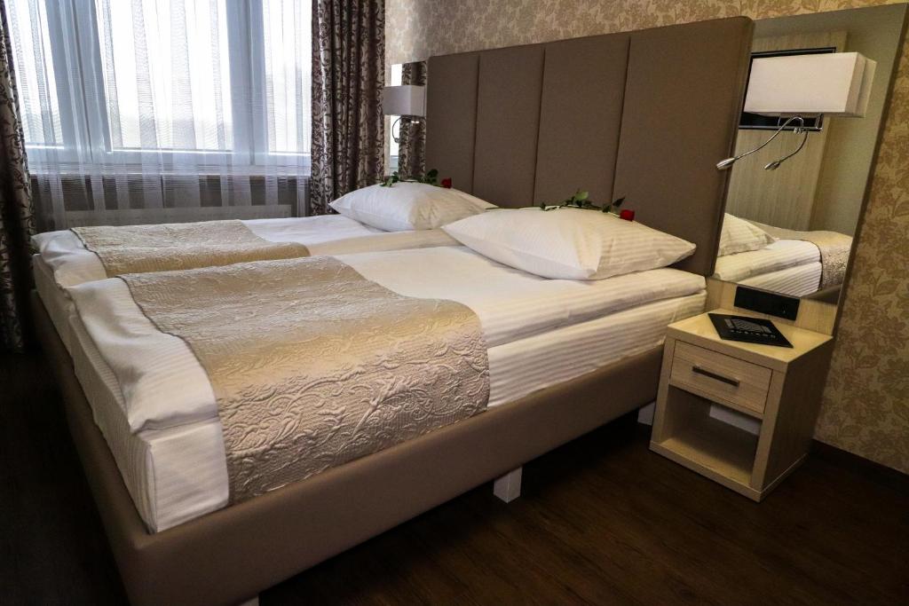 ルブリンにあるKompleks restauracyjno-noclegowy Rubikonの鏡付きの客室の大型ベッド1台
