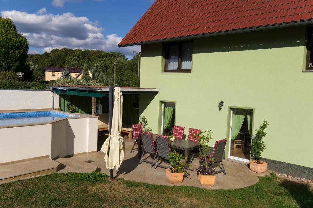 eine Terrasse mit einem Tisch und Stühlen neben einem Haus in der Unterkunft Ferienwohnung in der Telle in Schmalkalden