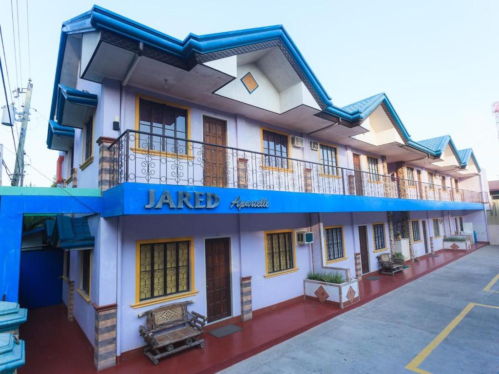 een hotel met een blauw-wit gebouw bij Jared Suites in Upper Digos