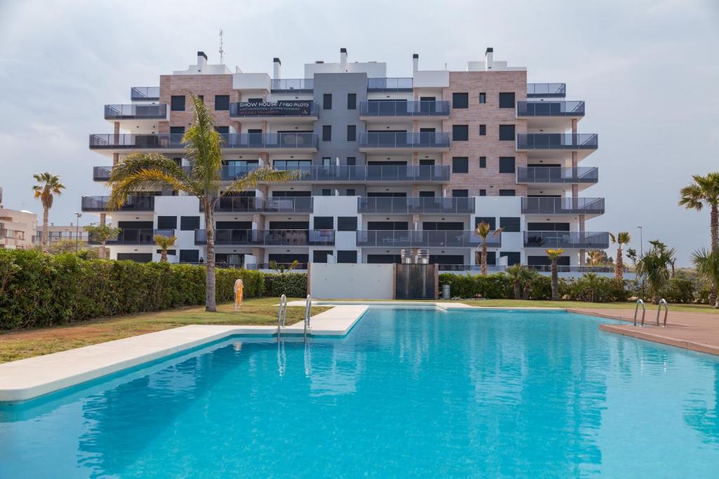 uma grande piscina em frente a um edifício em Apartment Vistamar I em Campoamor