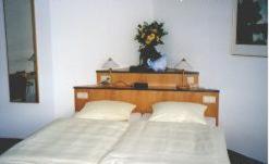 a bedroom with two beds and a headboard with two lamps at Gästehaus Hankhausen in Rastede