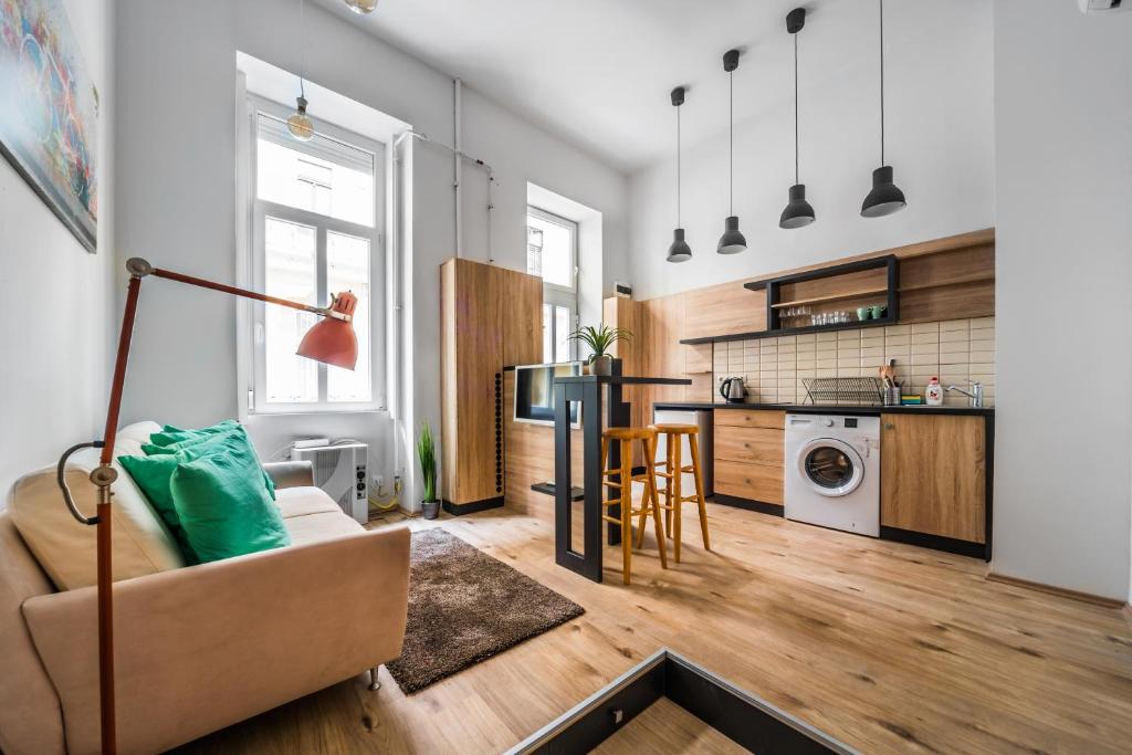 ein Wohnzimmer mit einem Sofa und einer Küche in der Unterkunft NEW DOB 53/3 CENTER APARTMENT in Budapest