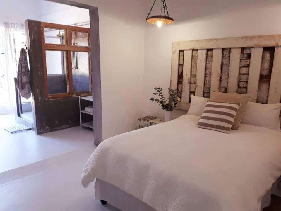Un dormitorio con una gran cama blanca y una ventana en The Last Eve Guesthouse, en Douglas