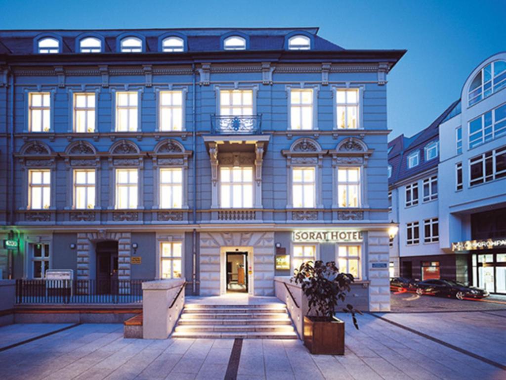 un grand bâtiment avec un panneau à l'avant dans l'établissement SORAT Hotel Cottbus, à Cottbus