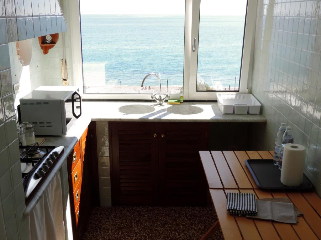 a kitchen with a sink and a large window at Le Casasse "Paradiso" in Varigotti