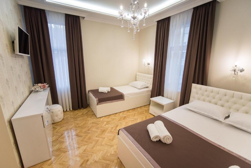ein kleines Schlafzimmer mit einem Bett und einem Sofa in der Unterkunft Center Deluxe Garni Hotel in Niš