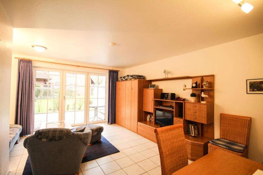 ein Wohnzimmer mit einem Sofa, einem Tisch und einem TV in der Unterkunft Ferienwohnung Gorch Fock Park Appartement 16 in Timmendorfer Strand