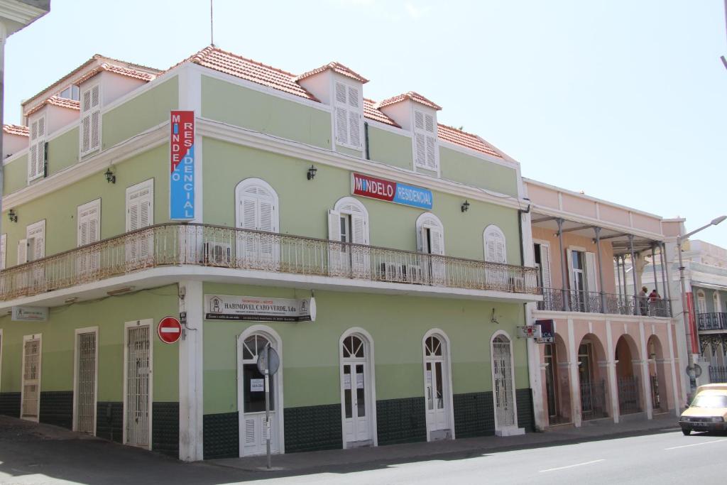 un bâtiment vert avec un balcon dans une rue dans l'établissement Mindelo Residencial, à Mindelo