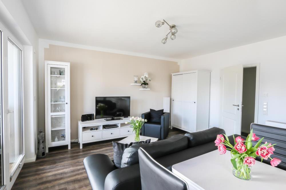 a living room with a couch and a tv at Ferienwohnung Strandhaus Möwenberg App.1 in Scharbeutz